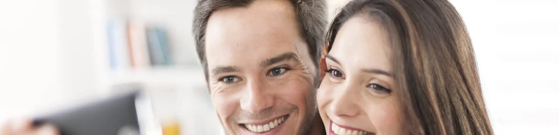A couple looking at a screen together at home