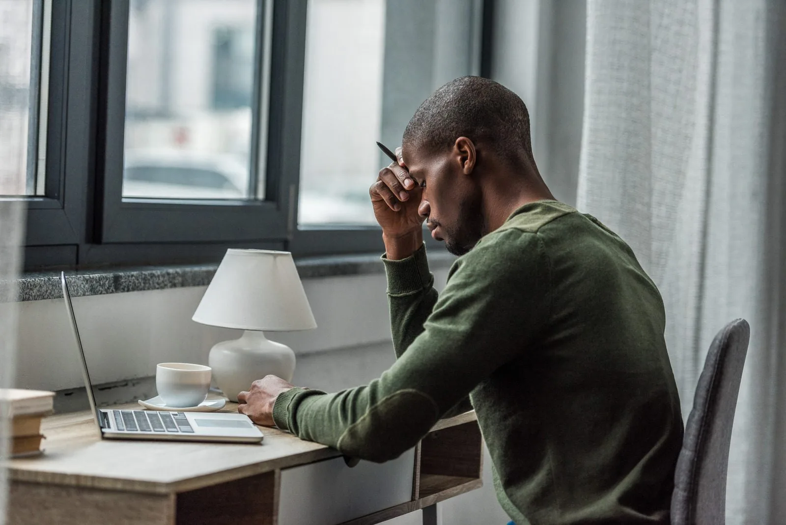 Man rubbing his eyes while working at a desk