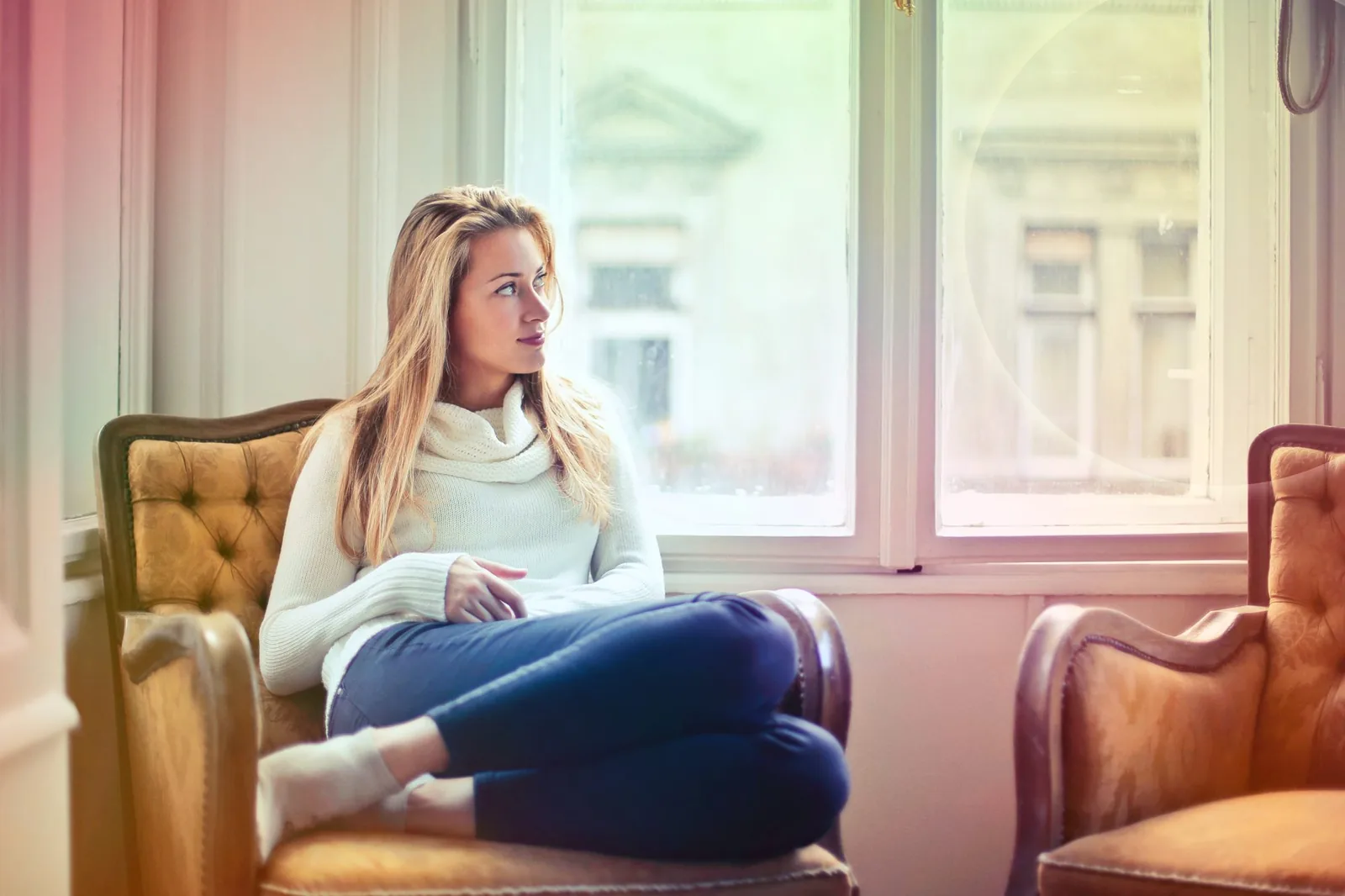 Woman relaxing at home with a coffee by the window